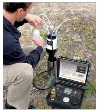 field technicial taking groundwater samples at waterloo system wellhead manifold